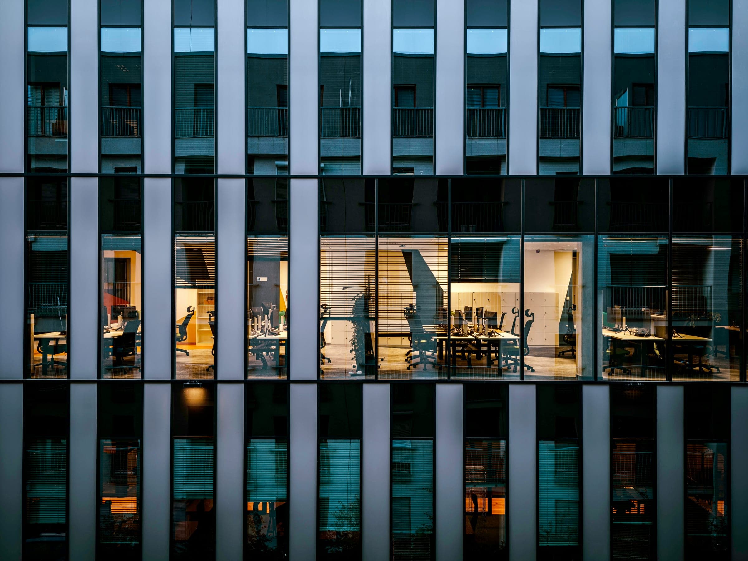 A lit office workspace inside a modern Detroit building at dusk